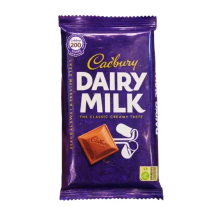 Cadbury Dairy Milk chocolate bar in purple wrapper held in hand with creamy milk chocolate design